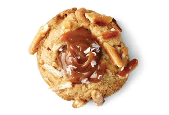 A salted caramel and pretzel cookie topped with flaked sea salt and pieces of pretzel.