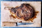 Cutting board and knife with a salt and pepper rib eye steak
