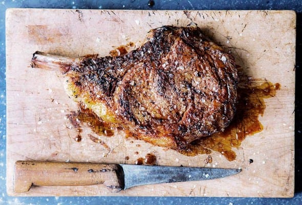 Cutting board and knife with a salt and pepper rib eye steak