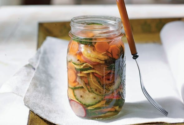 A jar of confetti quick pickles on a white napkin with a fork resting against the jar.