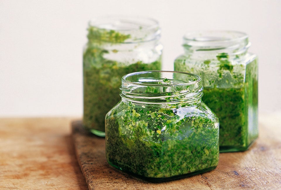 Three glass jars partially filled with pesto Genovese.