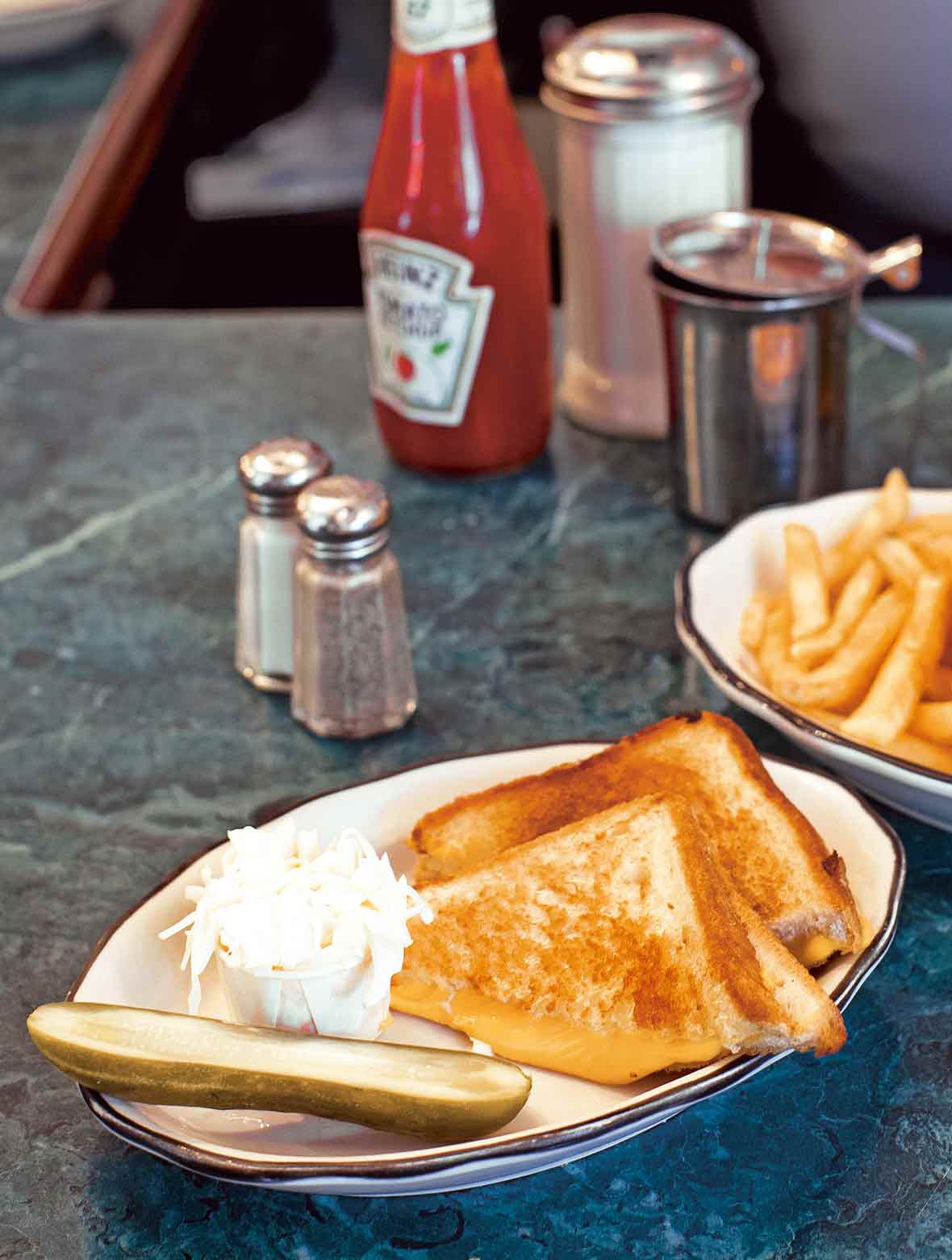A classic grilled cheese sandwich--buttered grilled bread and oozing Cheddar cheese