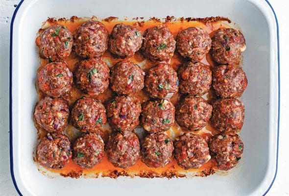 White pan of 24 orange-red chorizo golf-ball-size meatballs