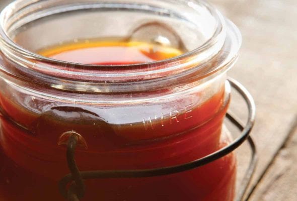 A canning jar filled with golden brown beef broth
