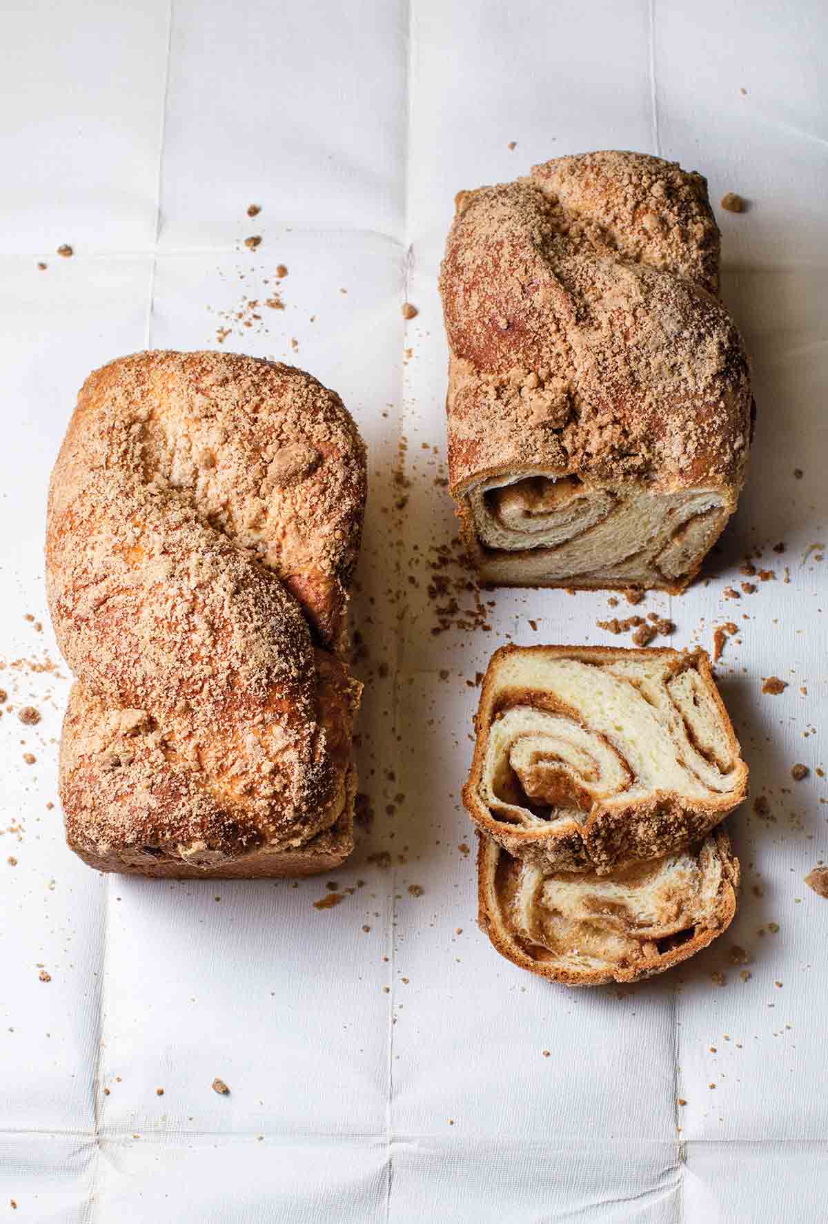 Two loaves of Hungarian coffee cake, one partially sliced to show swirled pattern inside.