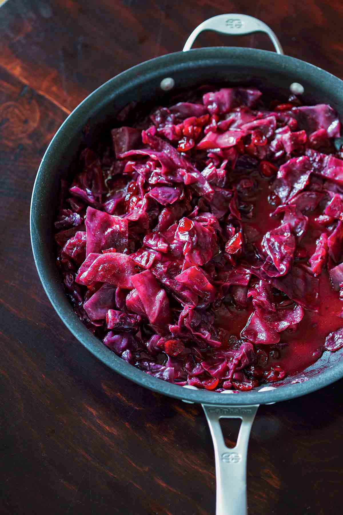 A Calphalon skillet filled with braised red cabbage with cranberries.