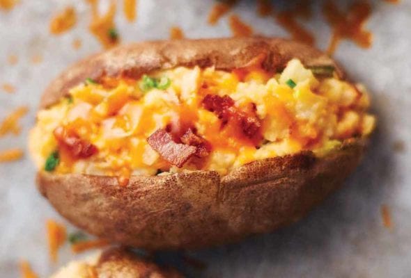 Baked potato, cut in half and stuffed with Cheddar cheese, bacon bits, sour cream, and chives