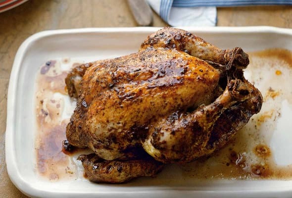 A whole Chinese roast chicken on a white tray.