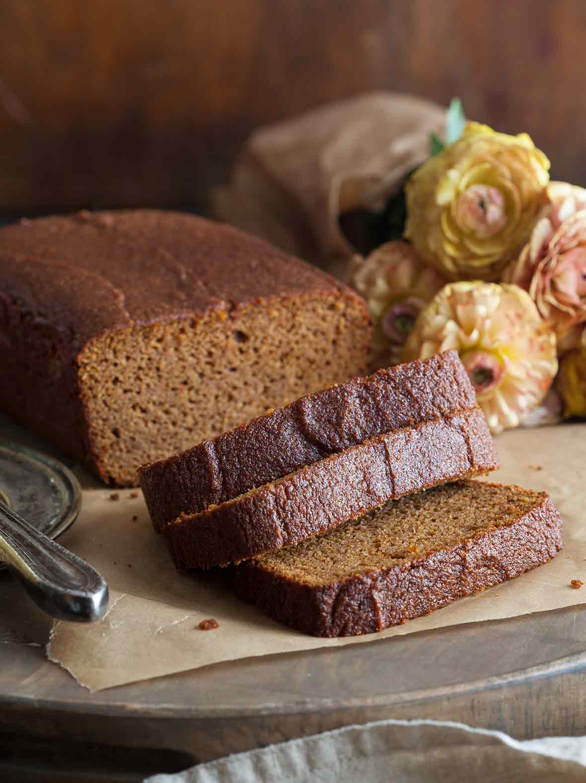 A loaf of paleo pumpkin bread with three slices cut off the end.