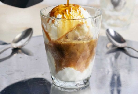 Espresso being poured over gelato in a cup to make affogato.