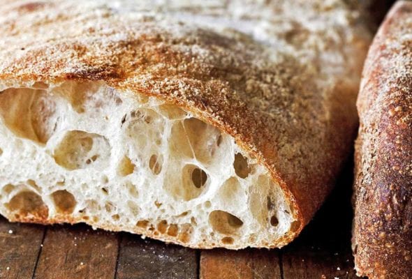 A loaf of ciabatta, sliced, and filled with large air holes