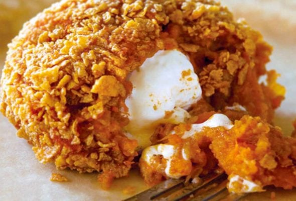 An inside-out sweet potato coated in corn flakes, with a marshmallow center.