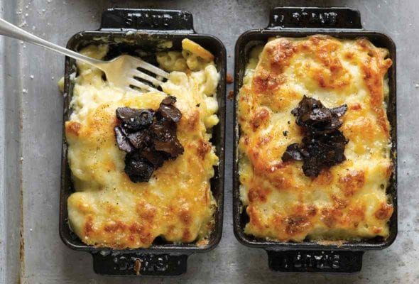 Two individual baking dishes with mac and cheese, topped with truffles