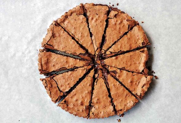 Chocolate tart cut into 12 slices on parchment paper