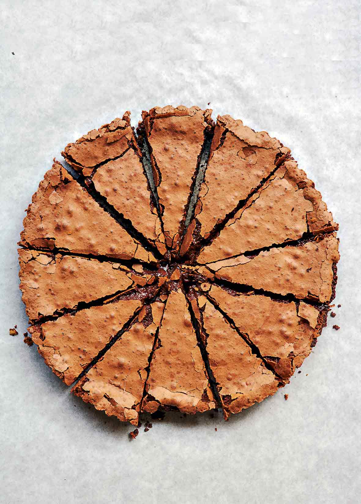 Chocolate tart cut into 12 slices on parchment paper
