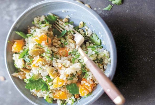 Bol of finely chopped celery root salad with chunks of clementines, pumpkin seeds, and parsley