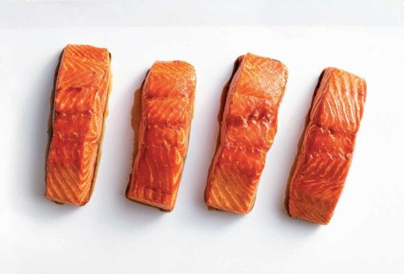 Four fillets of maple glazed salmon of a white square platter