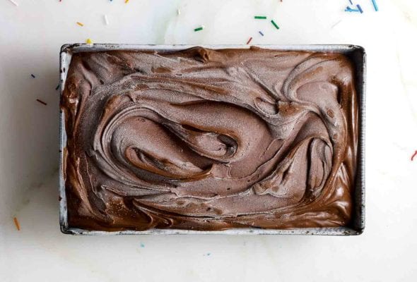 Metal loaf pan filled with swirls of dark devil’s food cake chocolate ice cream on a marble slab