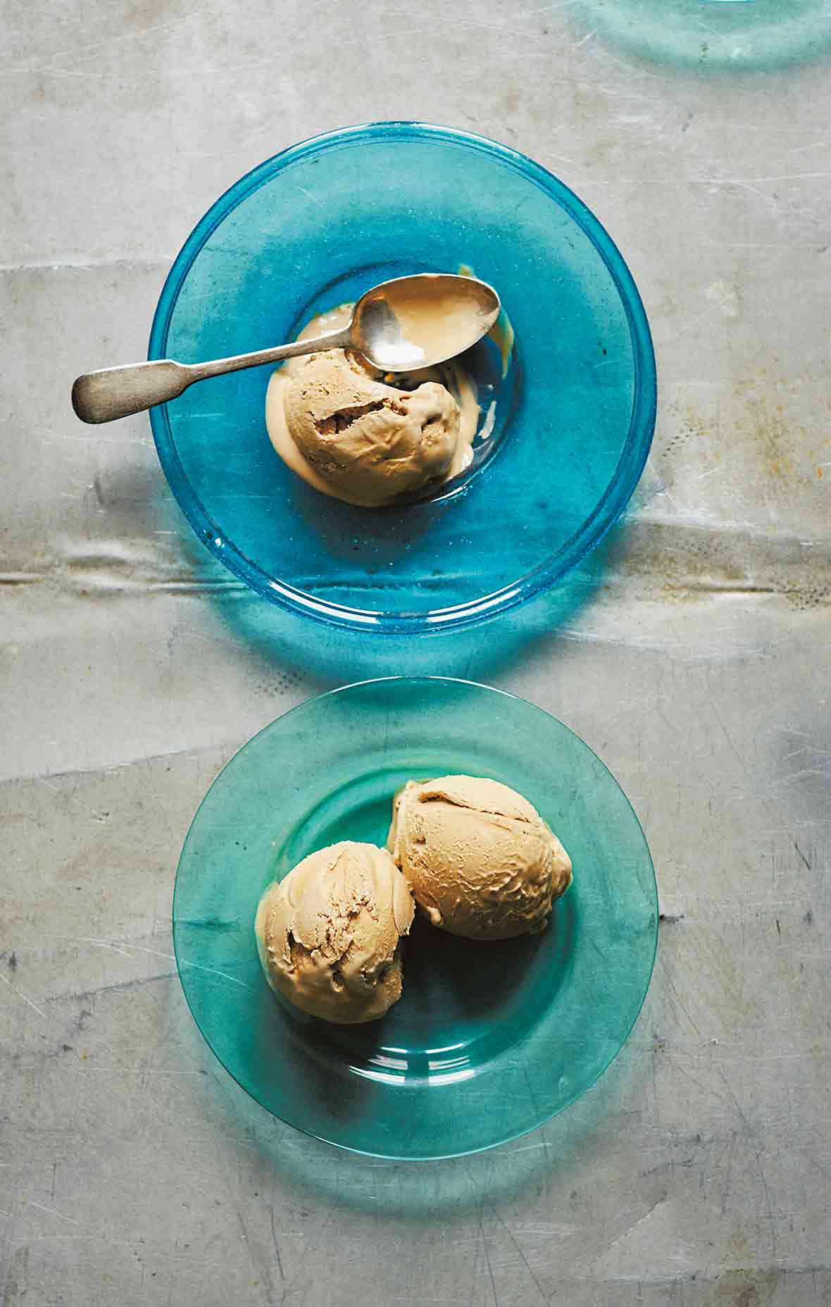 Two blue glass plates with scoops of Turkish coffee ice cream, and a spoon