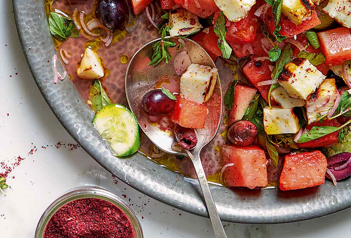 Bowl of watermelon, halloumi and za’atar salad, which also has cucumbers, olives, and grapes