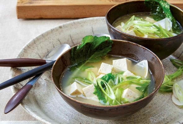 Two bowls of ginger miso soup with tofu, turnip greens, and miso broth