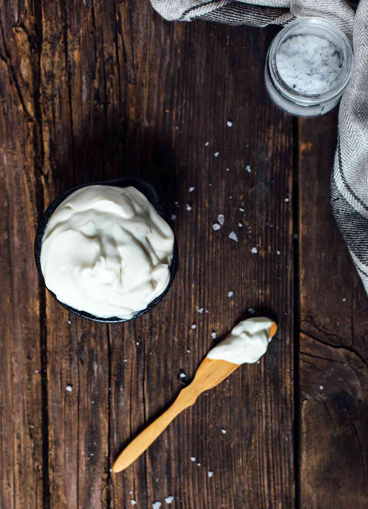 A small bowl of vegan mayo--soy milk, oil, vinegar, mustard, and salt--nearby is a wooden knife