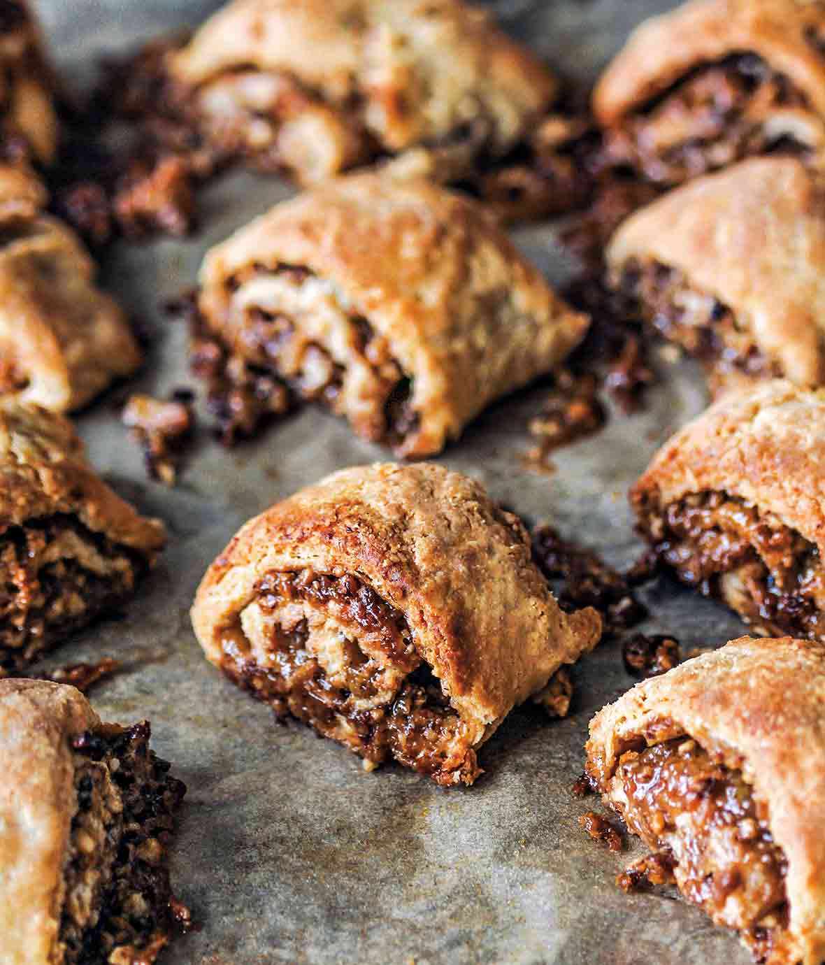 A dozen golden brown pecan pie rugelach with filling oozing out