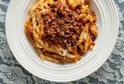 White bowl of venison Bolognese made with ground venison, carrots, onion, celery, mushrooms a top rigatoni