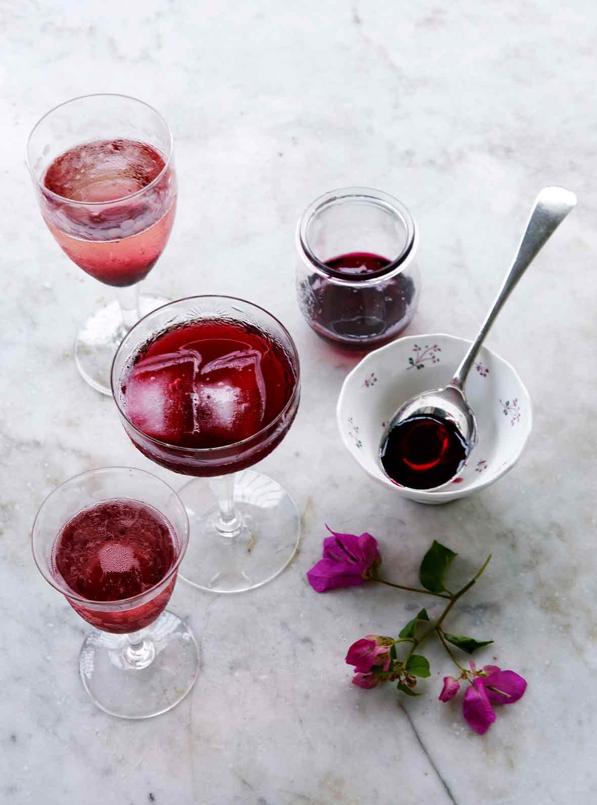 Several glass filled with purple Christmas hibiscus cocktail