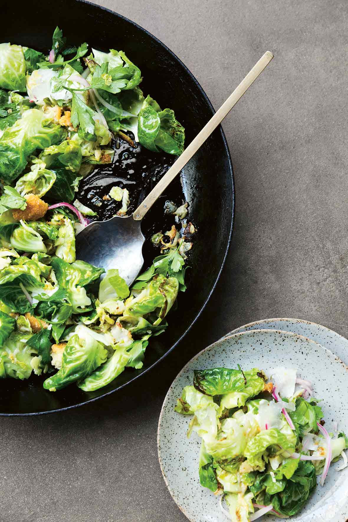 A big bowl of Brussels sprouts Caesar salad with sliced Brussels sprouts, pickled red onion, croutons, Pecorino cheese, and Caesar dressing