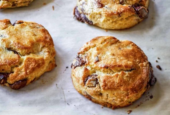 A baking sheet with seven chocolate pecan scones