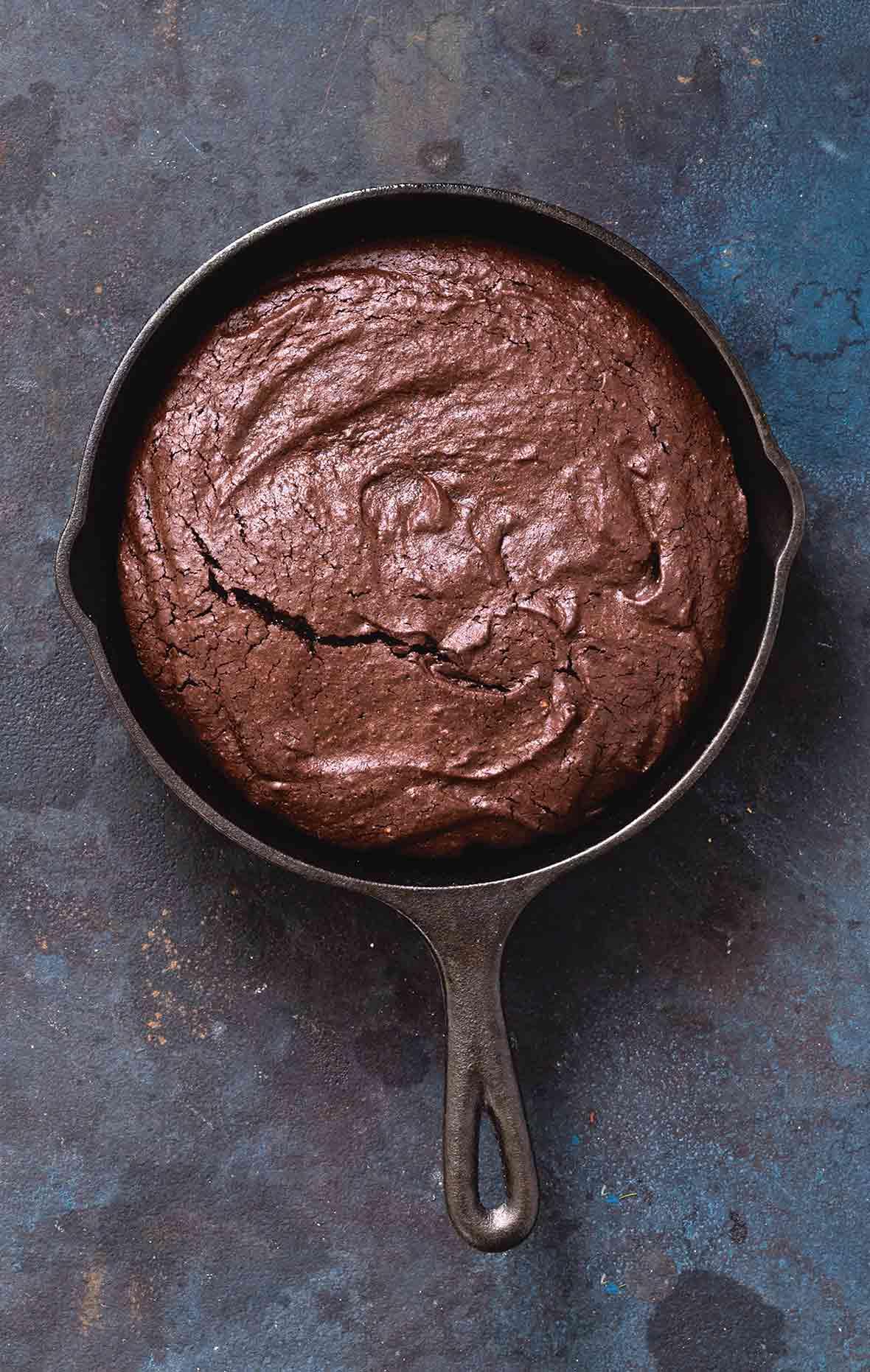 A cast-iron skillet filled with chocolate brownie