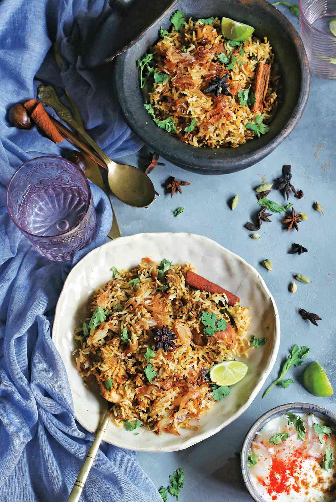Two bowls filled with chicken biriyani on a blue cloth