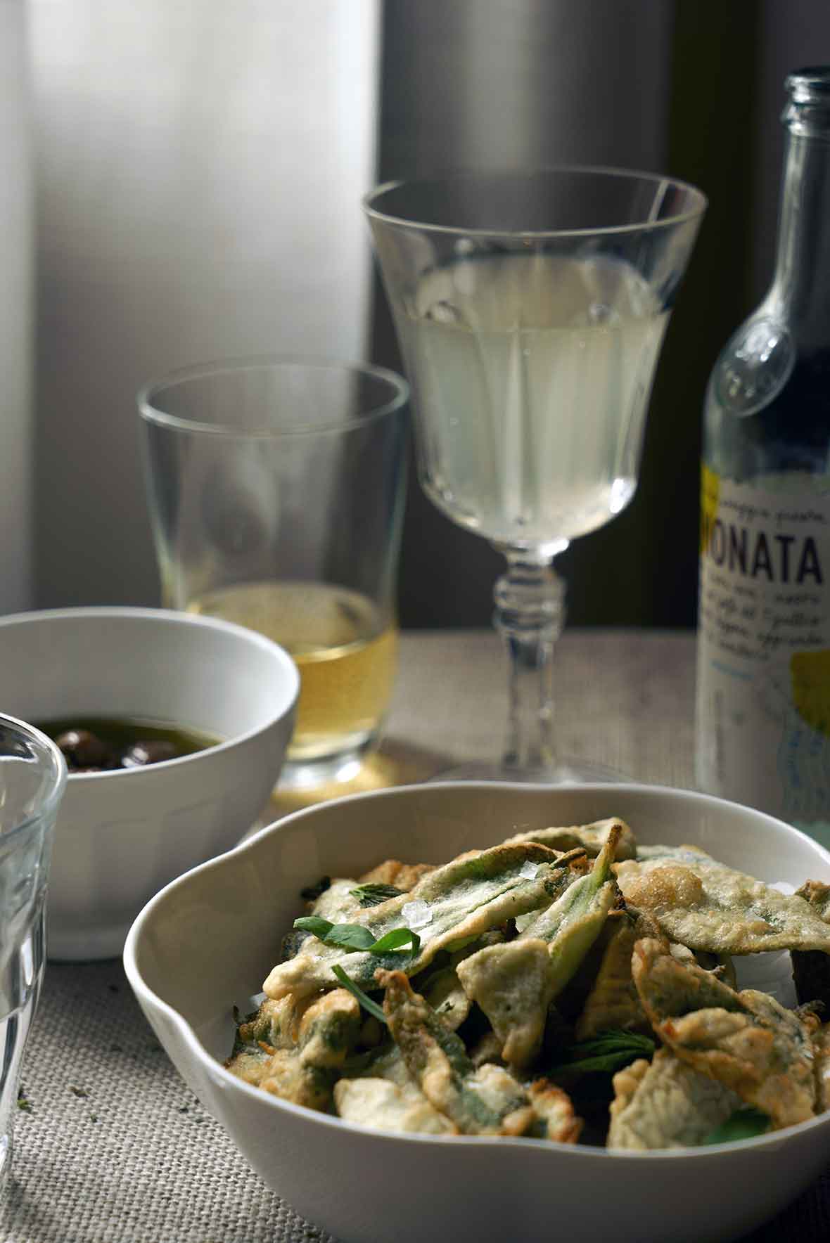 A white bowl filled with crispy fried sage leaves