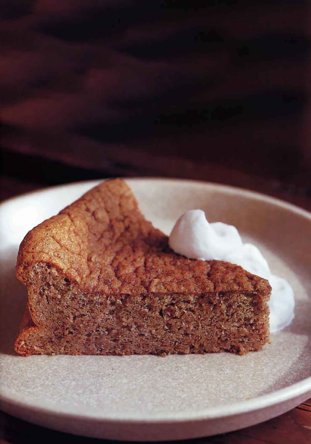 A slice of pecan torte with bourbon whipped cream dolloped on the side