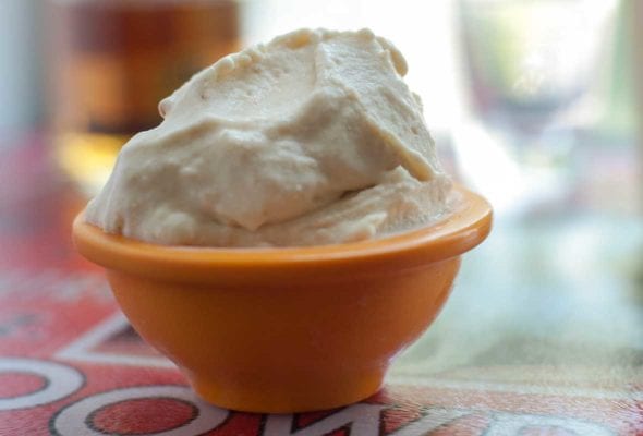 A small orange bowl filled with whiskey and fig gelato