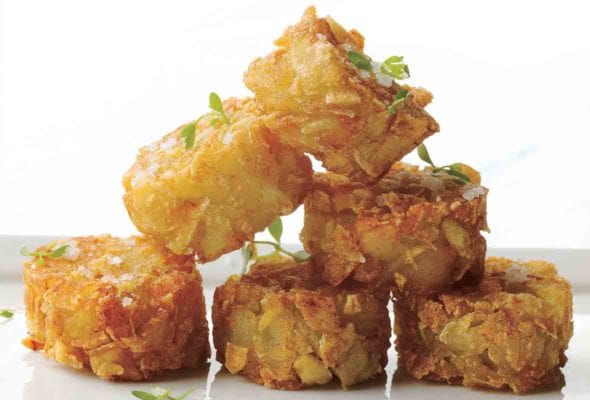 A stack of six homemade tater tots, sprinkled with sea salt.