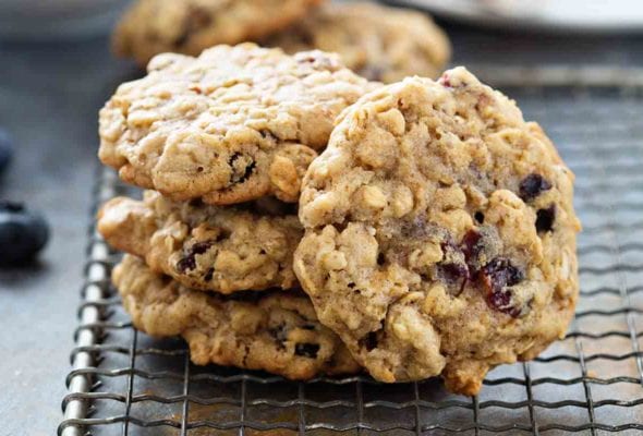 A stack of several oatmeal raisin cookies on a wire paddle.