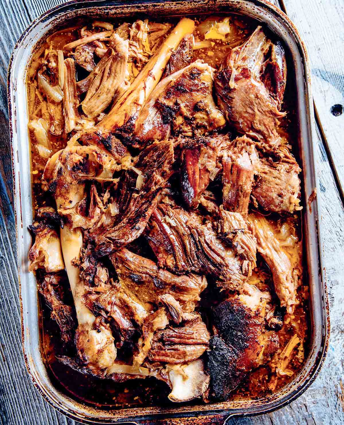A deep roasting pan filled with shredded lamb barbacoa.