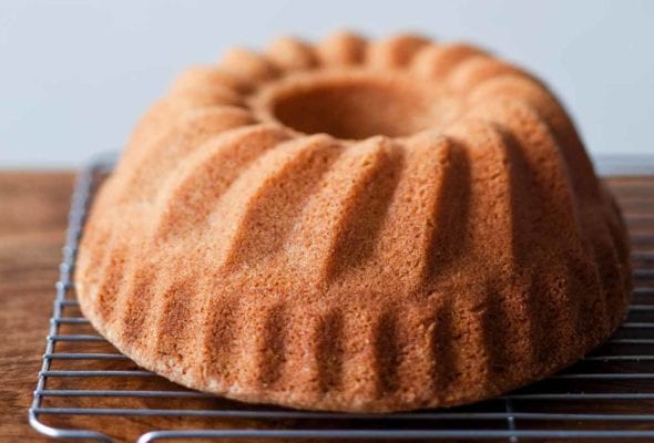 A whole ligurian almond cake cooling on a wire rack.