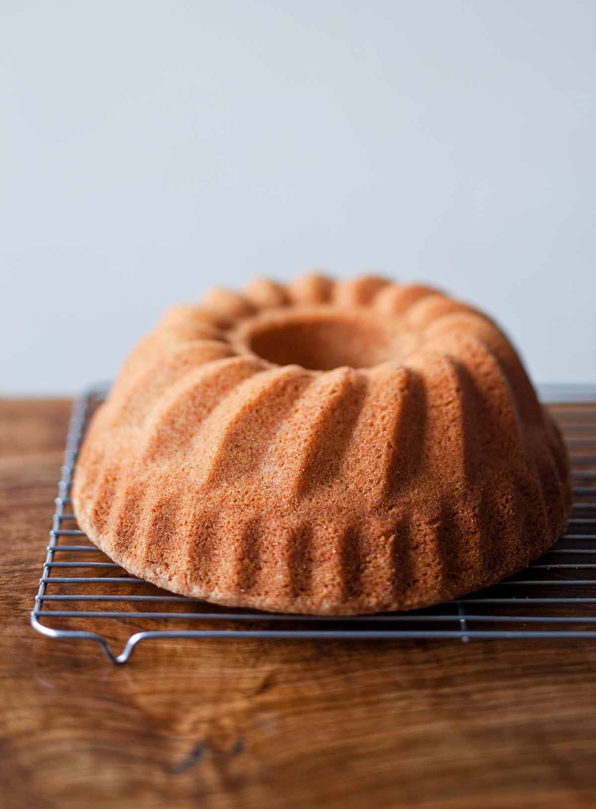A whole ligurian almond cake cooling on a wire rack.
