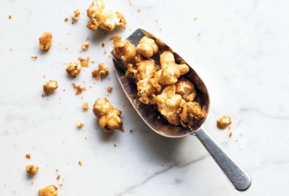 A metal scoop filled with maple caramel corn.