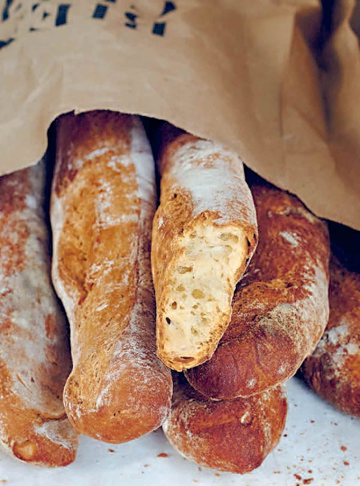 A paper bag filled with loaves of pane Francese.