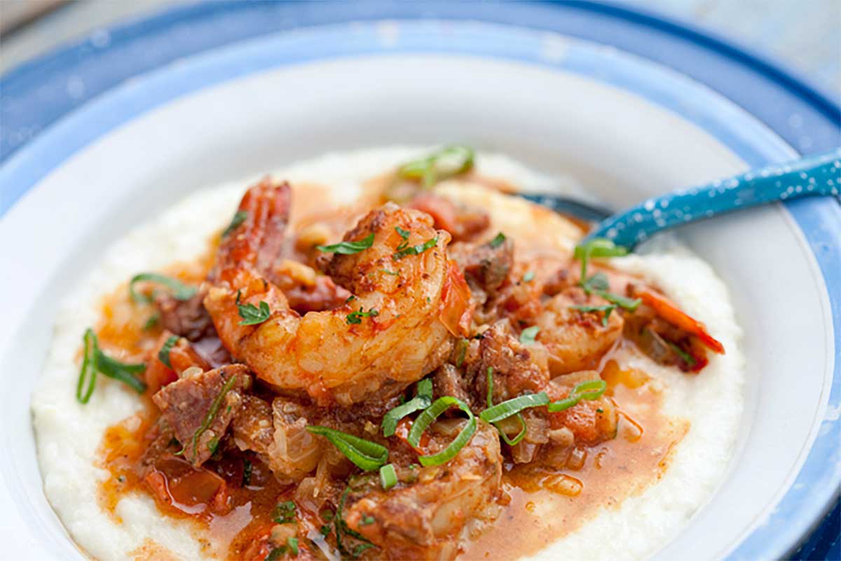A blue and white bowl filled with shrimp and grits.