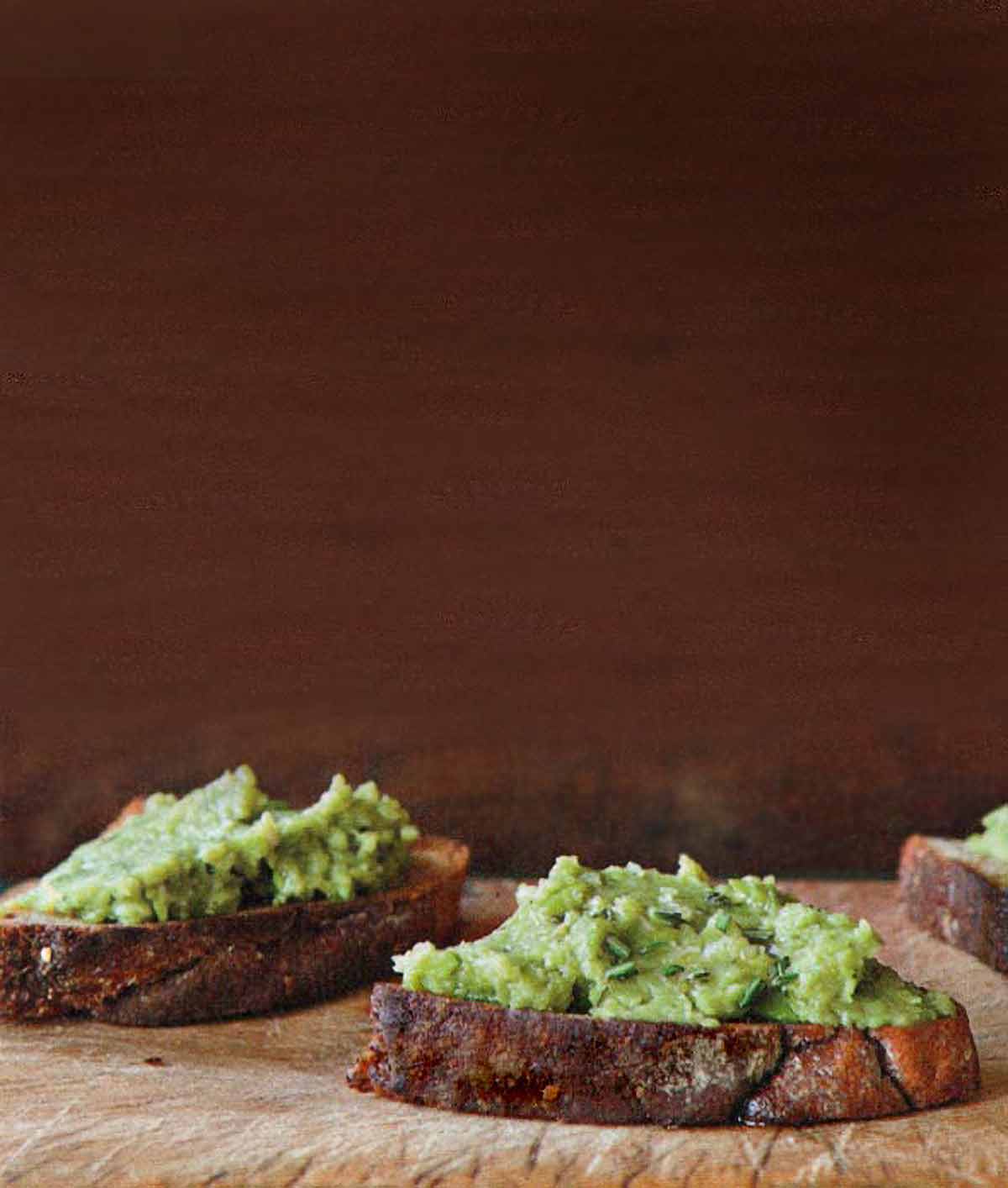 Three pieces of bread topped with fava bean puree.