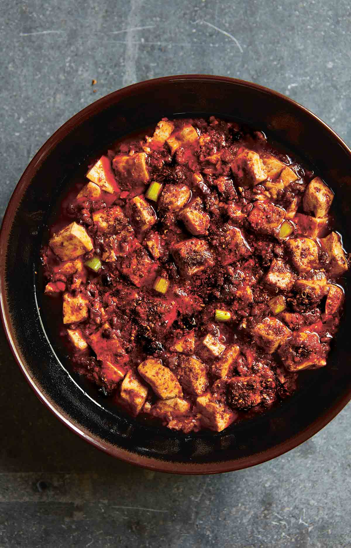 A brown ceramic bowl filled with mapo tofu.