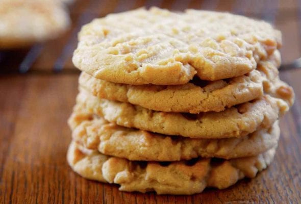 A stack of five old-fashioned peanut butter cookies, with crosshatch marks on top