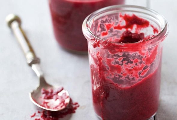 Two glass jars of homemade chrain with a silver spoon lying beside them.