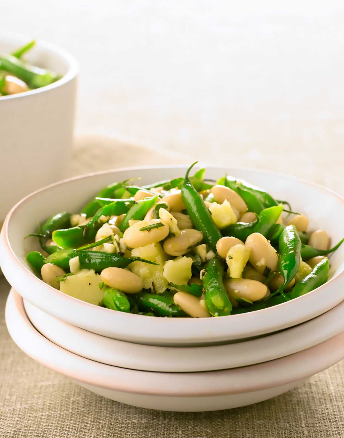 A white bowl filled with pecorino and bean salad.