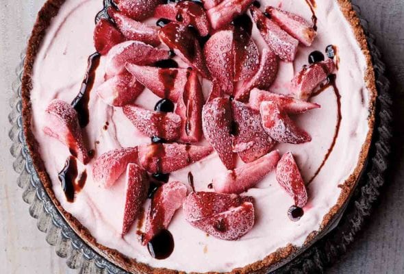 A whole strawberry ice cream pie in a fluted tart pan.